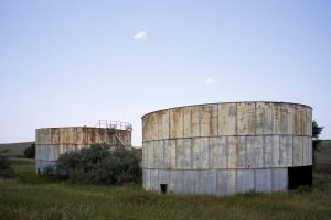 Abandoned infrastructure is ubiquitous from previous booms in western North Dakota. Two holding tanks for oil located near Keene, North Dakota. Photo by David Nix 2015