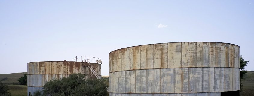 Abandoned infrastructure is ubiquitous from previous booms in western North Dakota. Two holding tanks for oil located near Keene, North Dakota. Photo by David Nix 2015