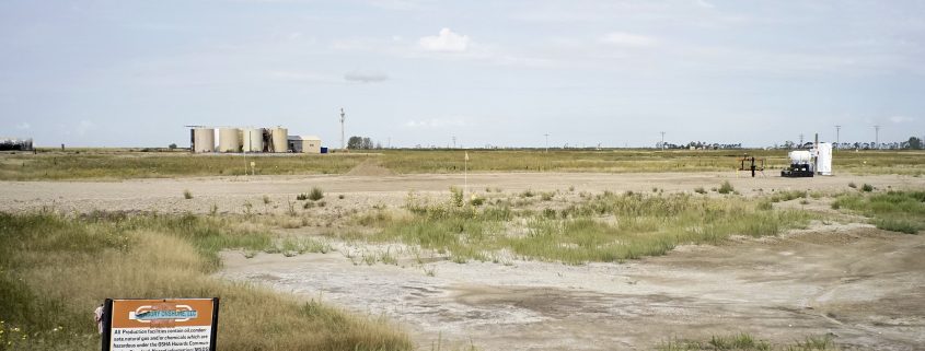 This is a highly impacted area near Antler, North Dakota in Bottineau county. In the distance you can see a slew of wells that are considered legacy wells from the previous booms. In the foreground you can see a secondary recovery injection well. Notice the washed out areas where the vegetation has been killed by the chlorides and other contaminants. Photo by David Nix 2015