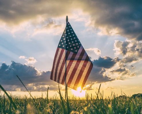American flag, sunset - Photo by Aaron Burden. Vote boldly!