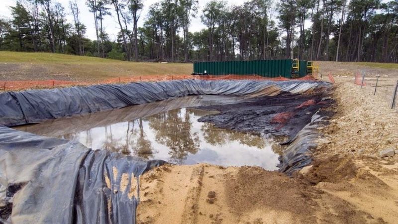 Open pits used to be permitted for temporary storage of oil and gas waste. Here, the liner is not properly covering the bottom-right corner, sludge is piled up past the liner in the top-right corner, and temporary fencing is failing in numerous locations. Photo by Barb Jarmoska.