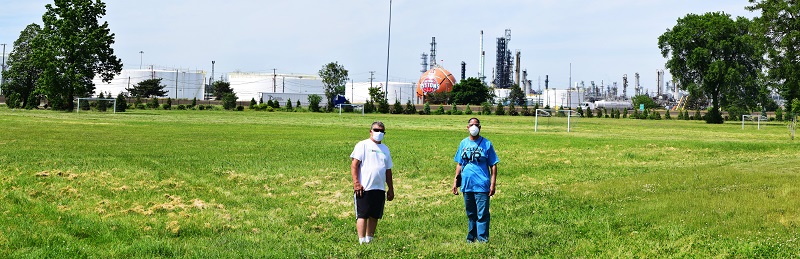 Detroit residents stand in front of a Marathon Oil refinery in southwest Detroit, MI, 2020. Photo by Ted Auch.